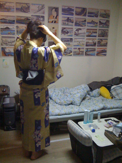 Hitomi Hitomi changing into her yukata -- gotta love the Ukiyo-e on the wall behind her!